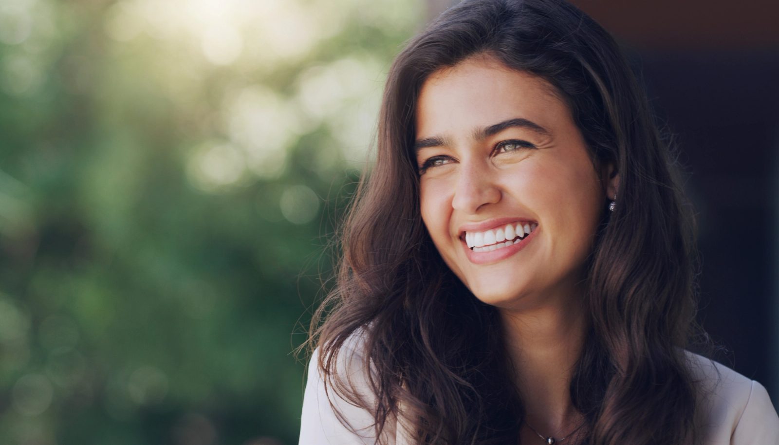 A close-up of a woman smiling with her eyes closed
