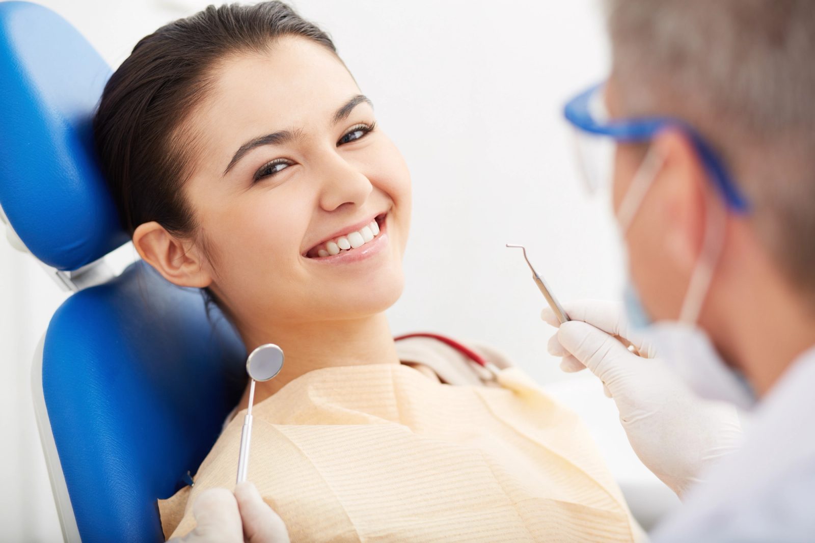 A smiling young woman in a dental chair during an examination