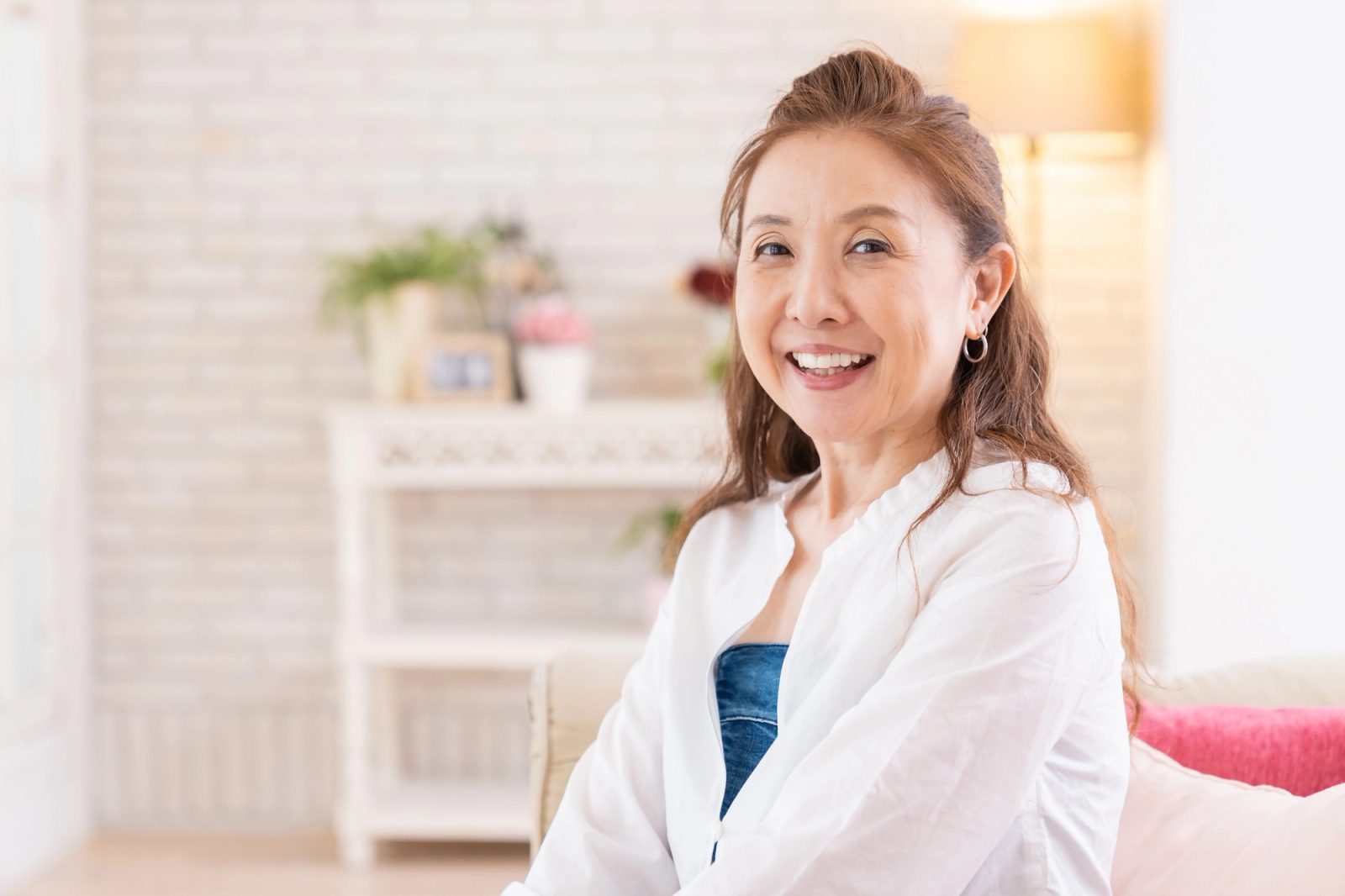 A smiling middle-aged woman in a white shirt
