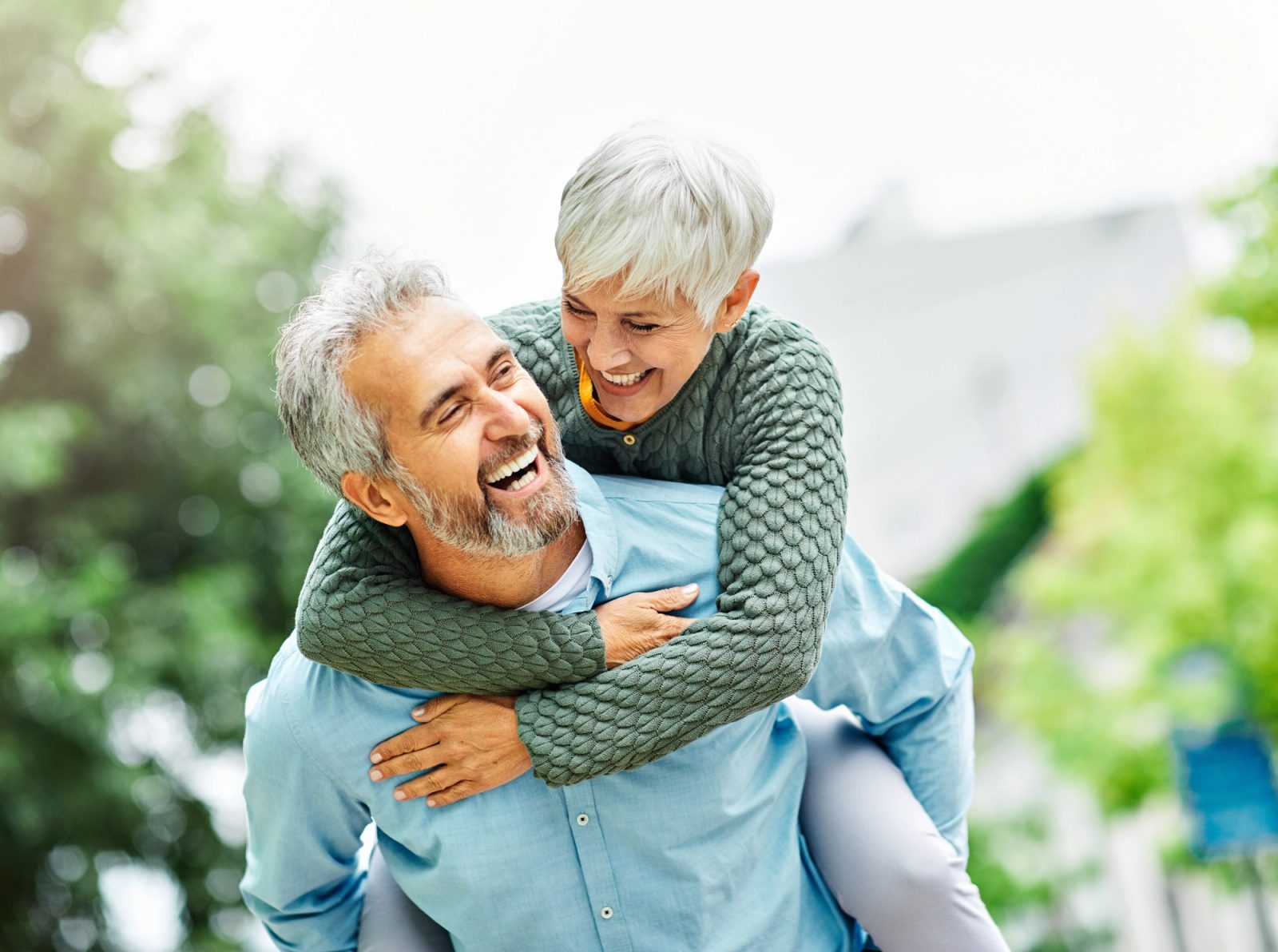An older couple laughs together outdoors